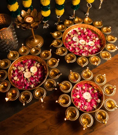 "Stylish metal urli set with classic brass diyas, adding a touch of elegance to any festive or decorative setting."